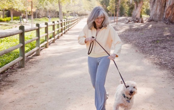 senior woman walking white dog