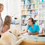 family and dog checking out at veterinary office
