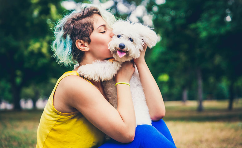 Woman kissing dog.
